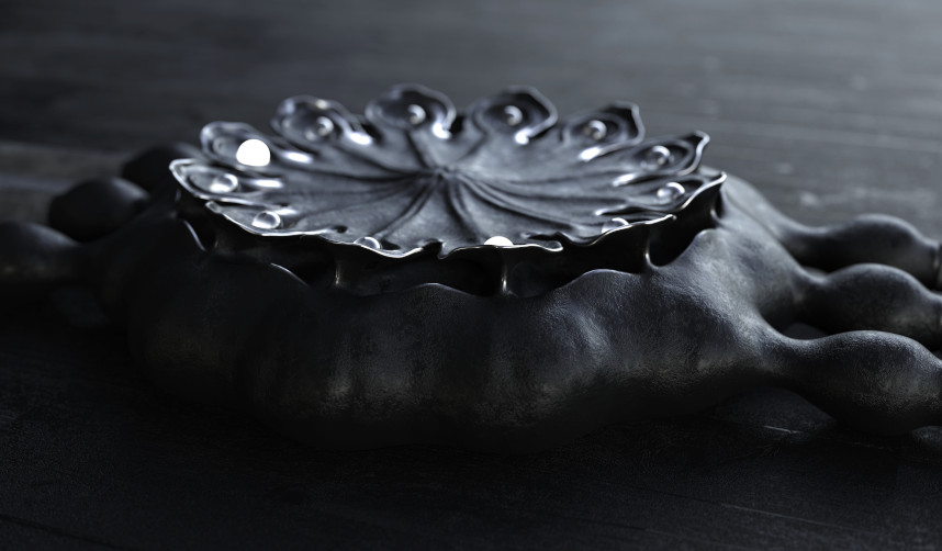 UnconstrainedTime Poppy Seed Pod watch in blackened silver on a black surface.