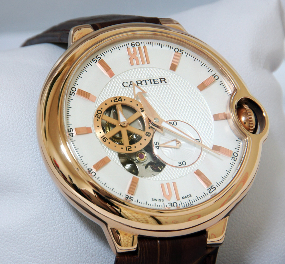 Cartier watch, gold with white dial, on white watch cushion