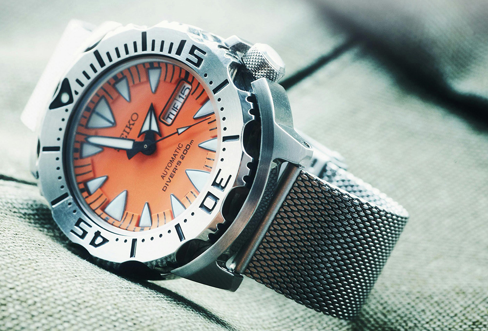 Seiko watch with orange dial, on fabric background