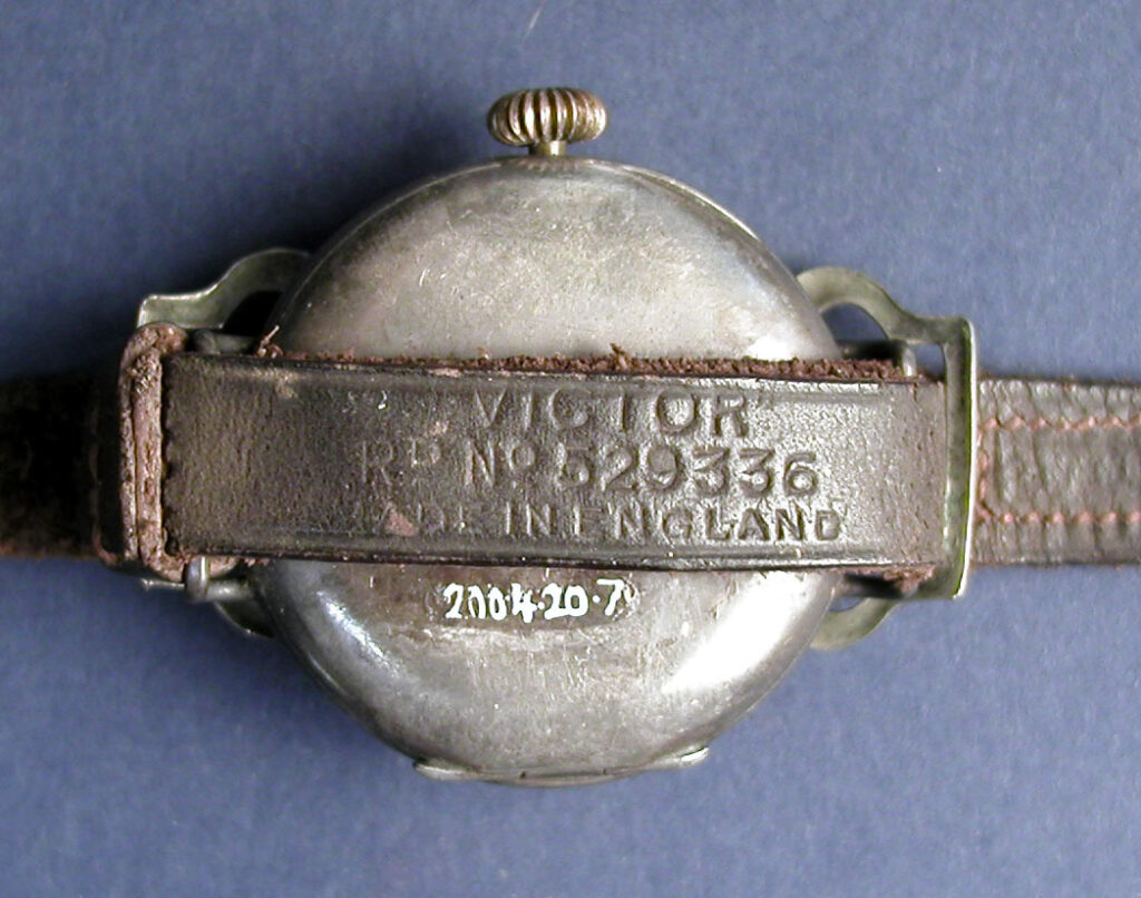 Wristwatch c. 1914 with leather strap, back view, on blue background