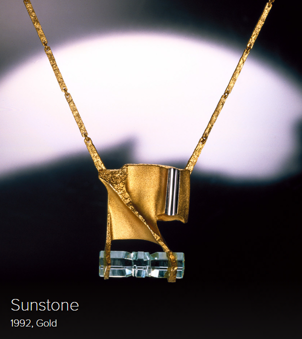 Art jewelry by Björn Weckström, gold with transparent stone, blurred background