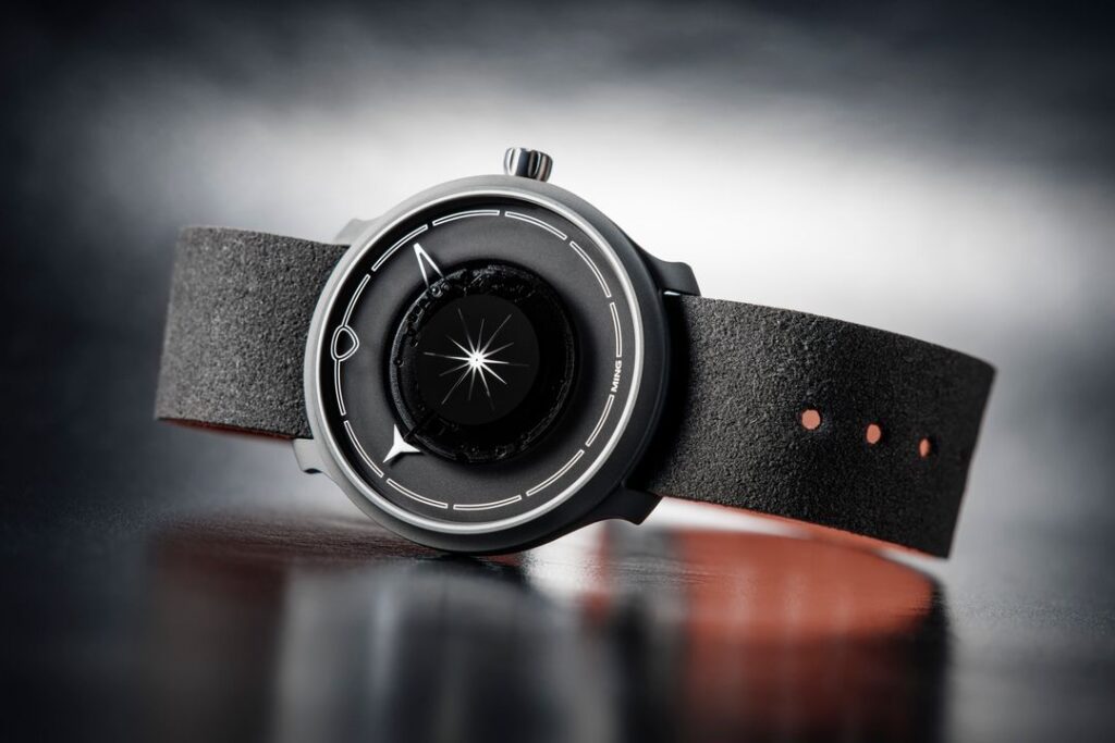 Ming watch - the lightest watch ever made, unique design, black, white and grey, on reflective surface.