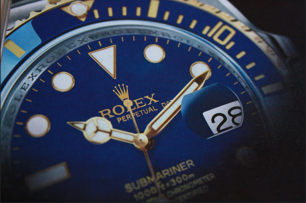 Rolex Submariner - a watch linked to an important event, detail/closeup, blue dial, white and gold hands and markers.