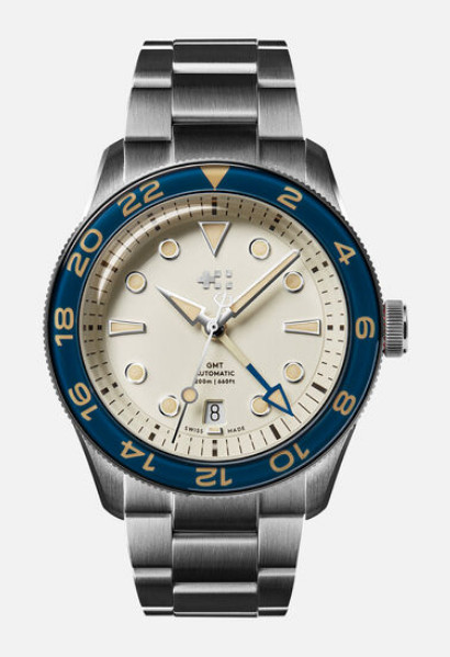 Christopher Ward C65 Aquitaine GMT, cream dial, blue bezel, on pale grey background.