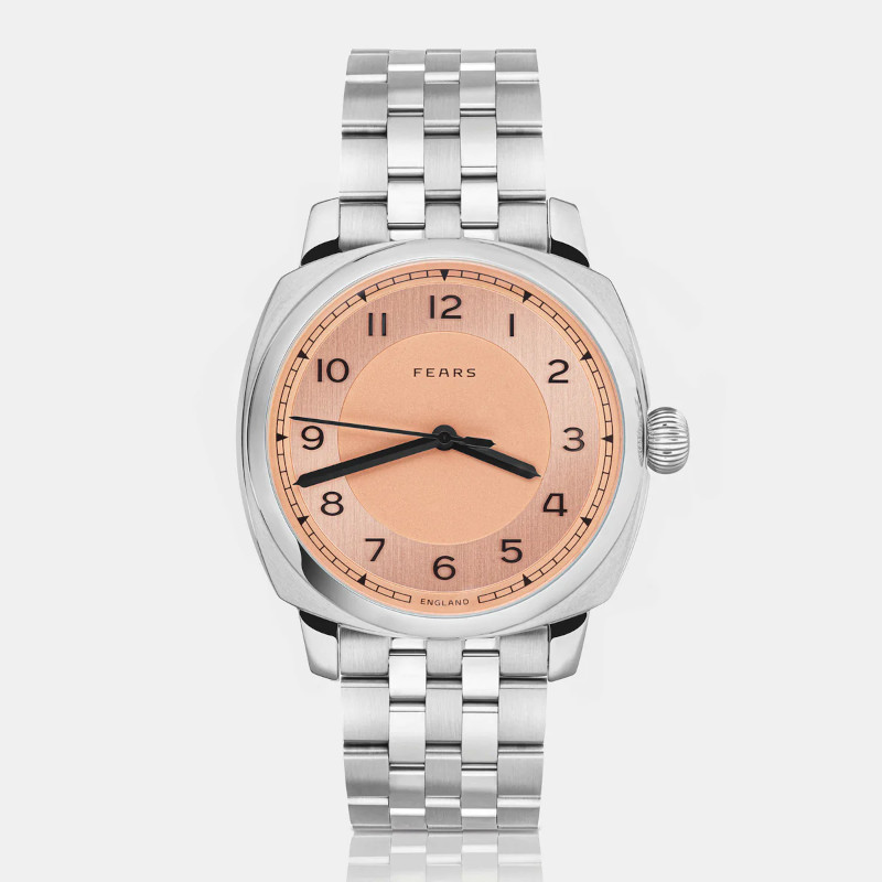 Fears watch with salmon dial, vertical view, on pale grey background.