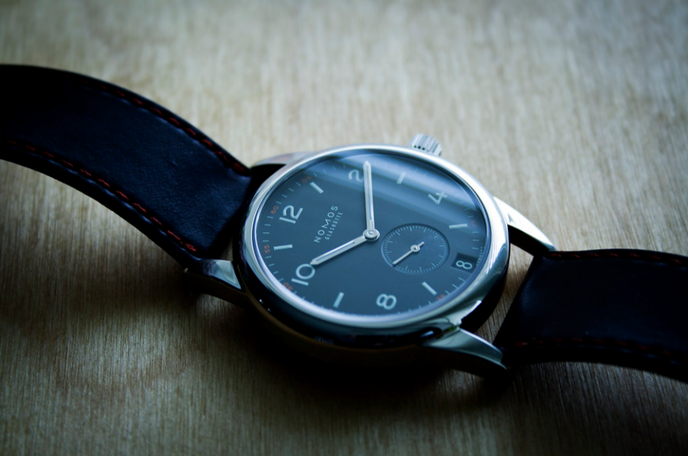 Nomos Glashütte watch, on a wood surface.
