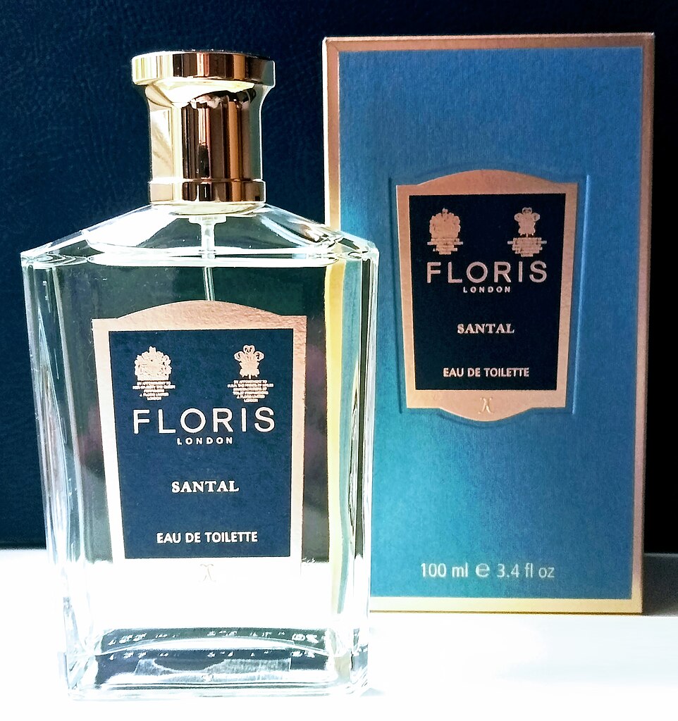 Floris perfume, in bottle, with box, on white surface, against dark background.