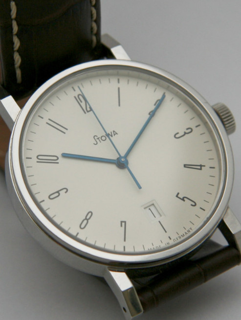 Stowa Antea watch - Bauhaus watch design aesthetic, simple clean design, white dial blue hands, on white surface.