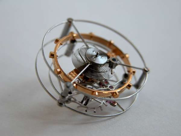 Tourbillon mechanism, metals, on white surface.