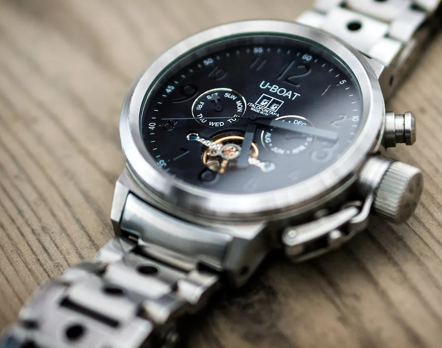 U-Boat microbrand watch, black dial, on wood surface.