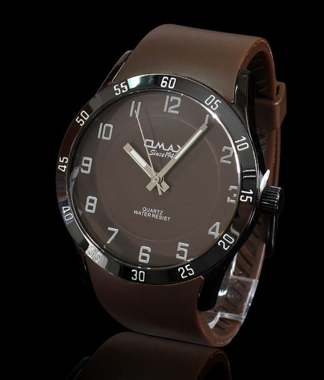 Brown watch with brown strap, vertical view, on black background.