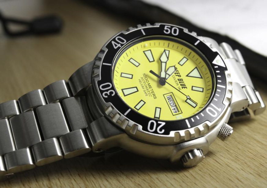 Yellow watch dial, on a watch by Deep Blue, on a wood surface.