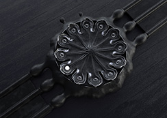 Poppy Seed-pod watch, black patinated bronze, view from above, on a dark surface. Thumbnail