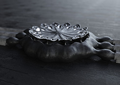 Poppy Seed-pod watch, black patinated bronze, on a dark surface. Thumbnail