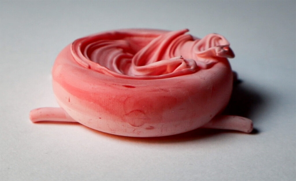 3D print in resin of a version of the body/case for Fractal Emergence watch 41mm, pink resin, on a white surface.