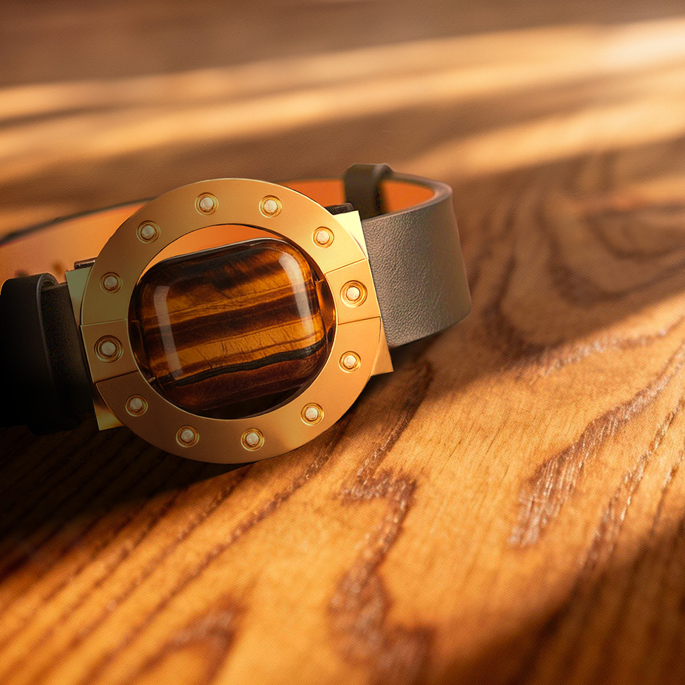 Stone-hold watch, gold with tigers eye, on sunlit wooden surface