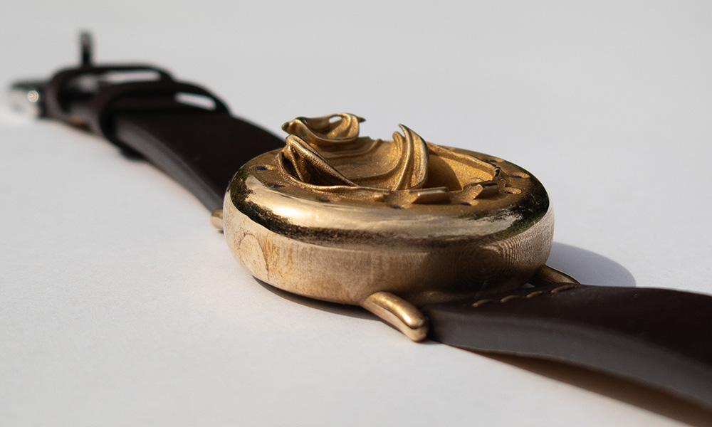UnconstrainedTime Fractal Emergence 41mm wristwatch in bronze, sunlit on a white surface.