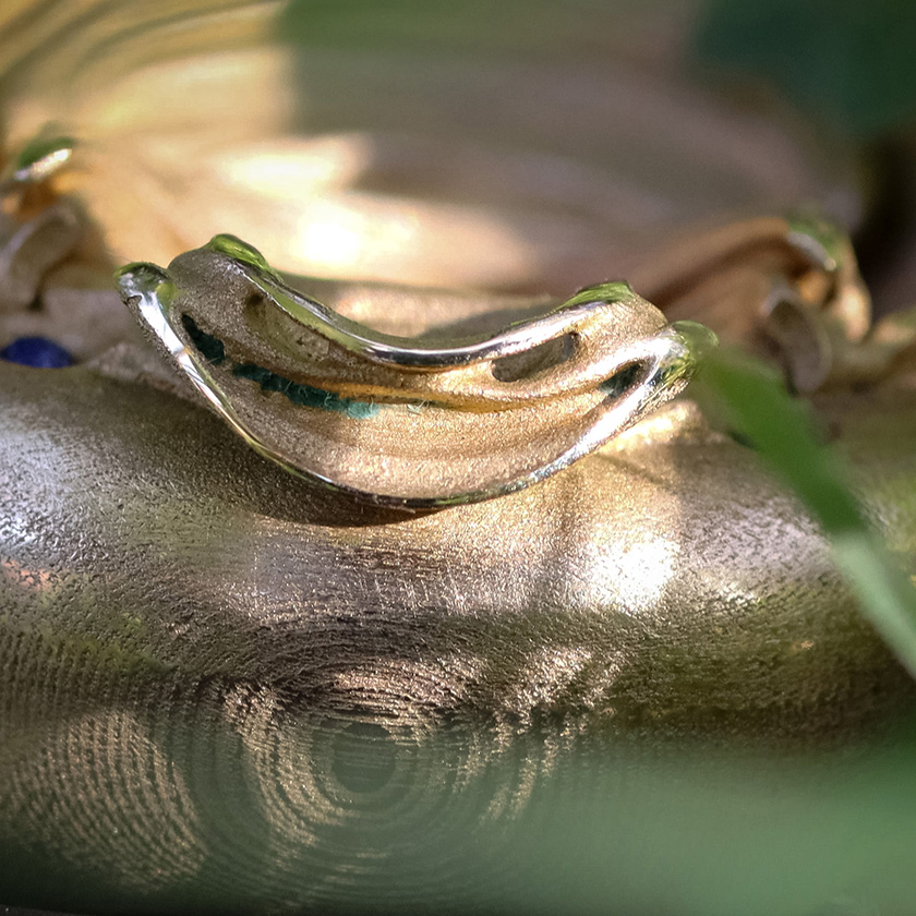 UnconstrainedTime Fractal Emergence wristwatch in bronze, closeup of the head of the fractal, in nature, with brown leather strap.