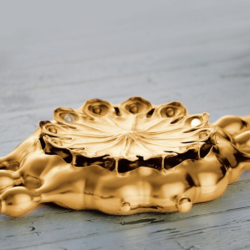 Poppy Seed Pod watch in gold, closeup on distressed paint surface.