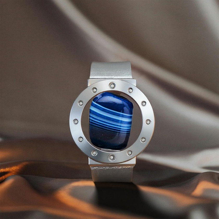 Stone-hold watch in platinum and blue agate, vertical with fabric background