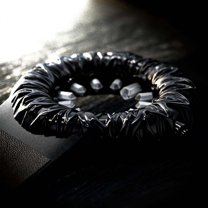 Tropical Crystal wristwatch in black, on a rough black surface, lit from the side.